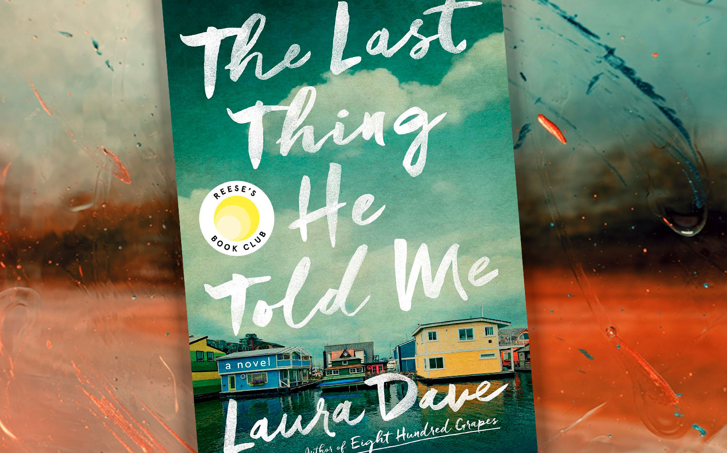 The cover of Laura Dave's The Last Thing He Told Me is shown. It features some houses positioned on a lake.