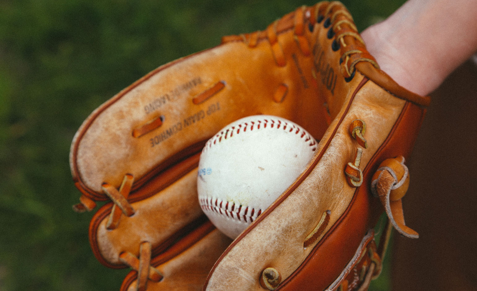 A baseball is shown resting in a baseball glove.