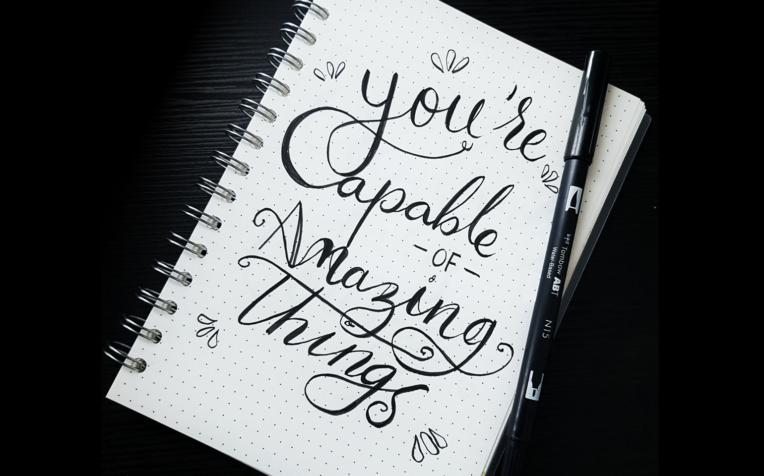 A notepad that reads "You're capable of amazing things" is shown. This is an example of a positive affirmation.