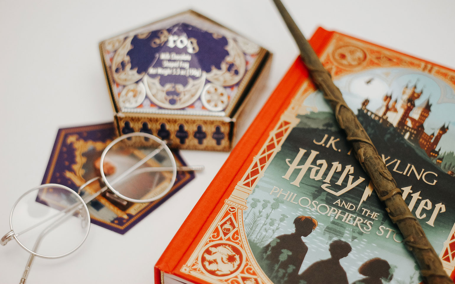 A wizard wand sits atop one of the Harry Potter books.